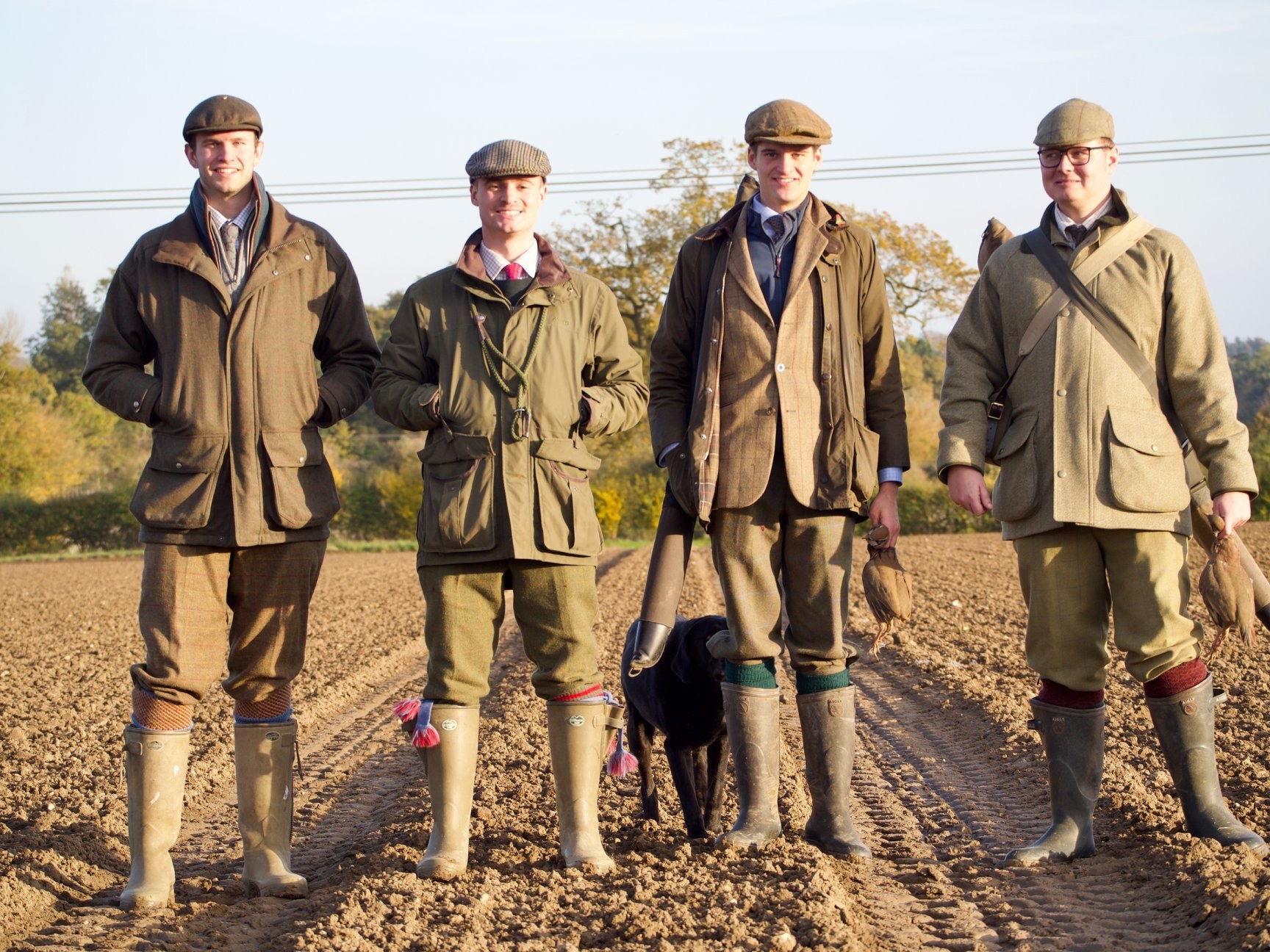Four guns at evening light on a ploughed field