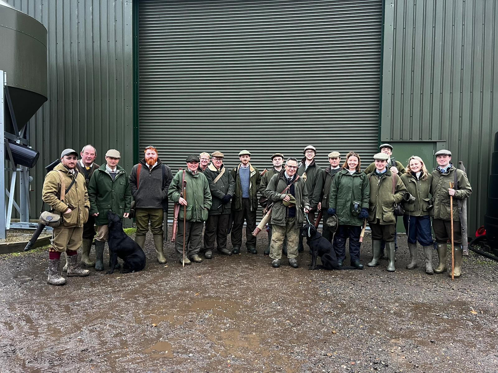 Full shooting party with guns and dogs at the end of a driven day