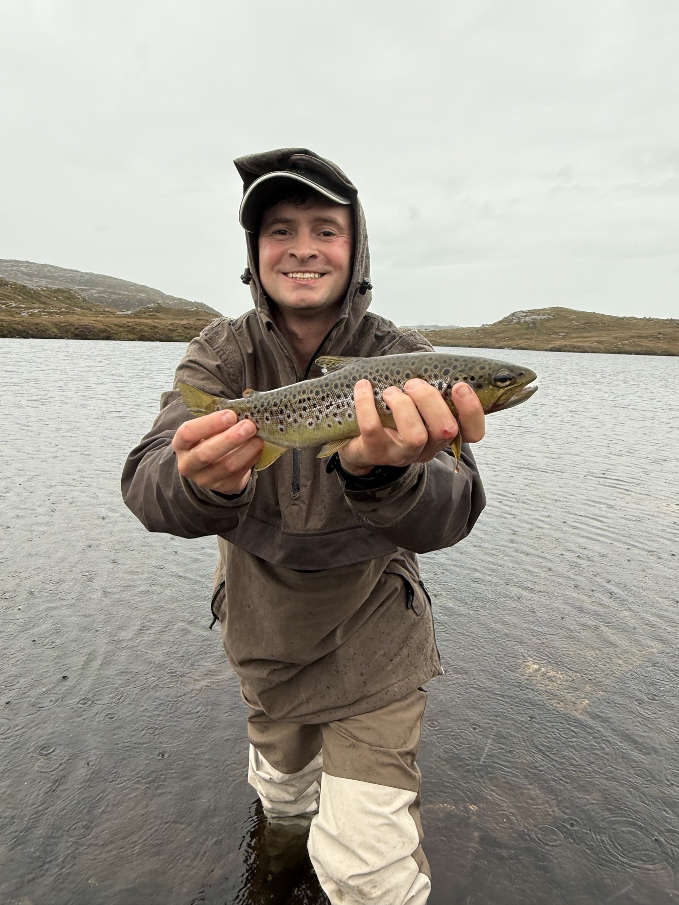 Hooded angler with brown trout