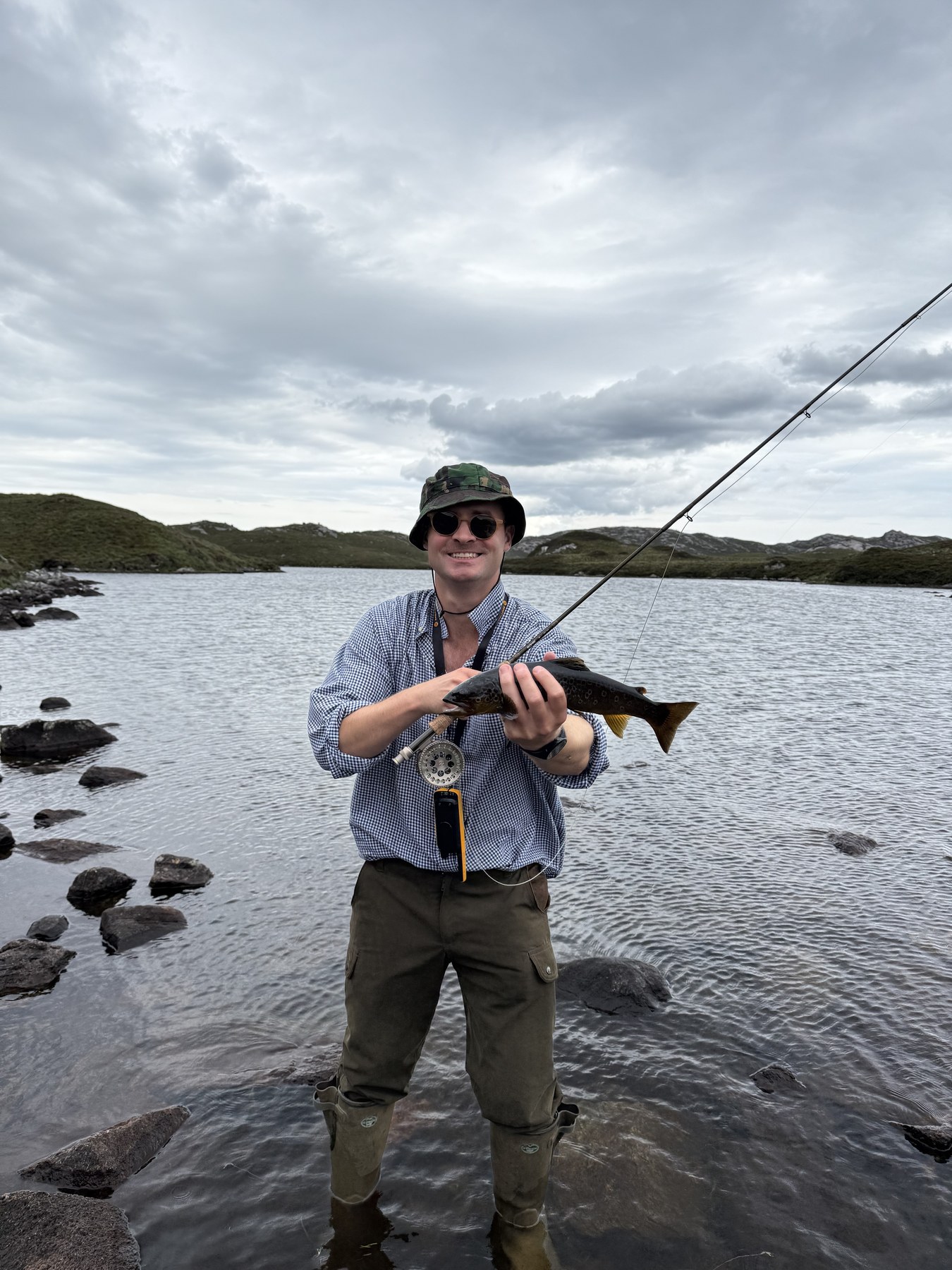 Angler with rod and brown trout