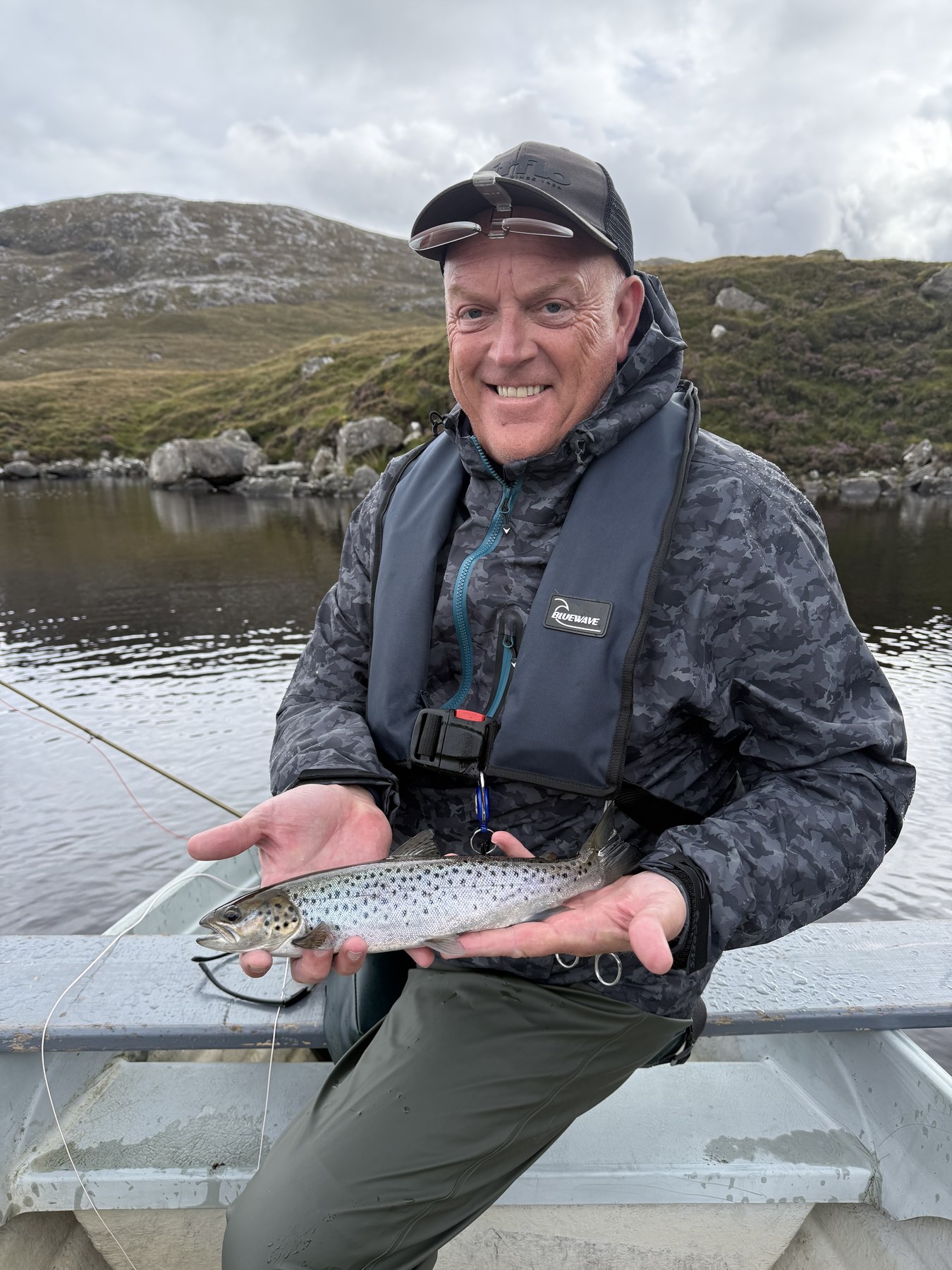 Angler with a sea trout in the Highland rain