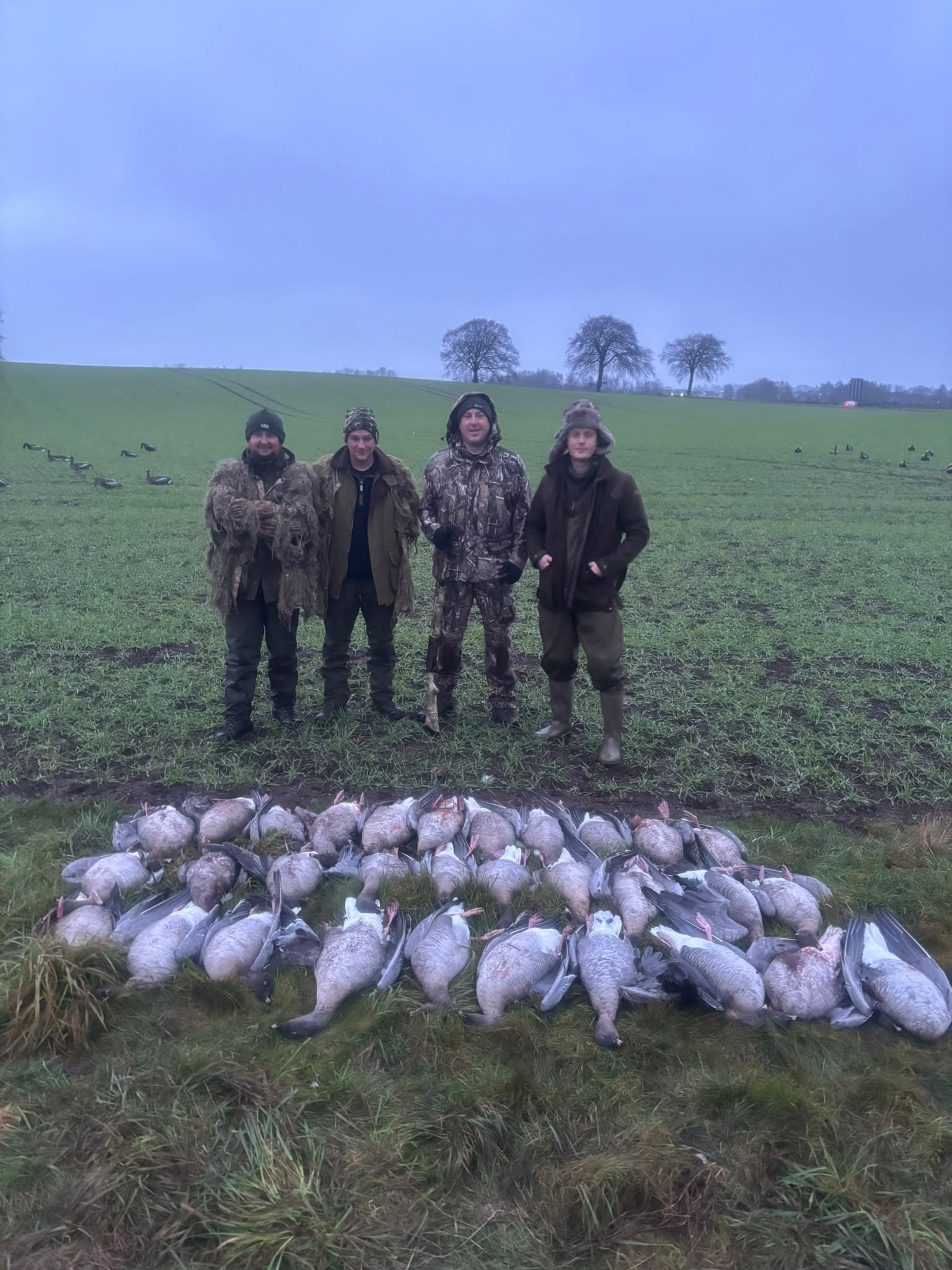 Four guns with a misty-morning bag of geese
