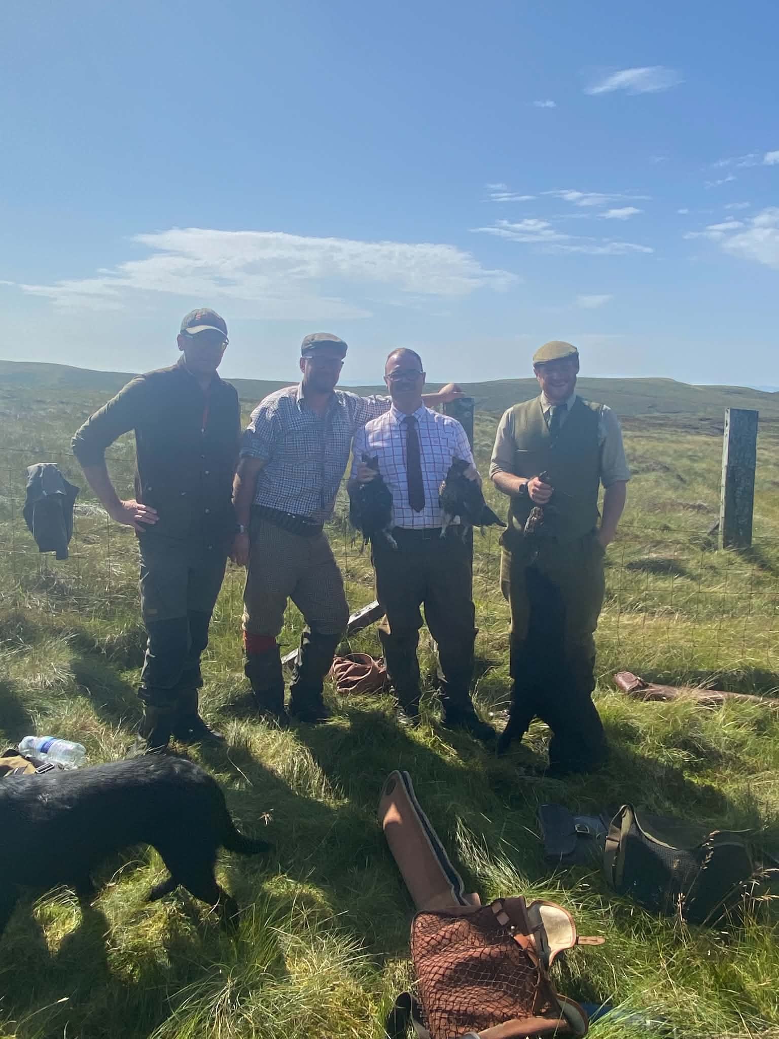 Four guns and a Labrador with grouse